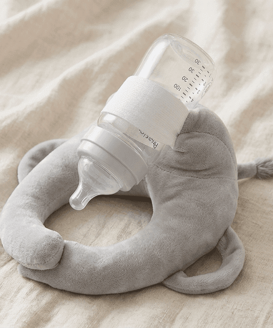 Sipee Sip grey feeding pillow holding a bottle