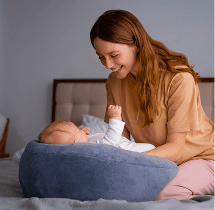 Baby resting on Sipee Sip feeding pillow at home