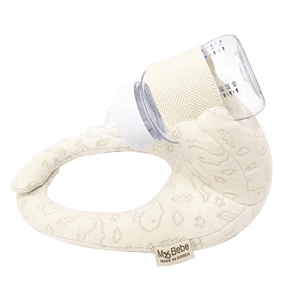 Sipee Sip hands-free baby bottle feeding pillow in cream holding a bottle